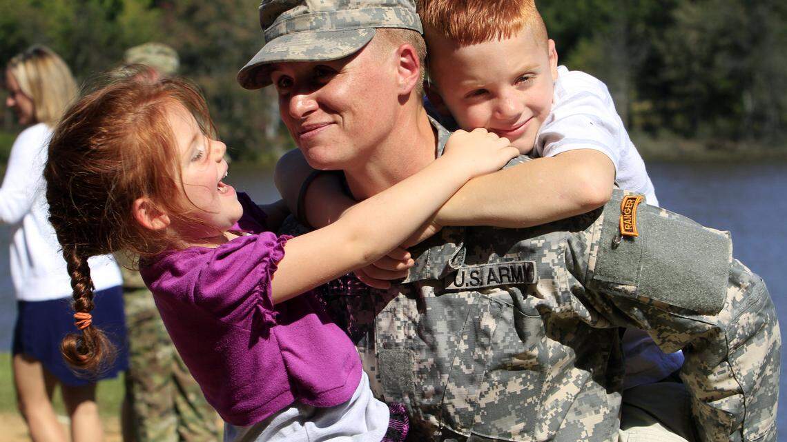 ROBIN TRIMARCHI rtrimarchi@ledger-enquirer.com 
 Maj. Lisa Jaster holds her daughter Victoria, 3, and her son Zachary, 7, following Ranger School graduation ceremonies Friday at Victory Pond. She kept photographs of her famiily with her for 180 days of Ranger training. Jaster, who is the third woman to earn the Ranger Tab, entered Ranger training with Capt. Kristen Griest and 1st Lt. Shaye Haver, who were the first two women to graduate from Ranger School during ceremonies on August 21. 10.16.15