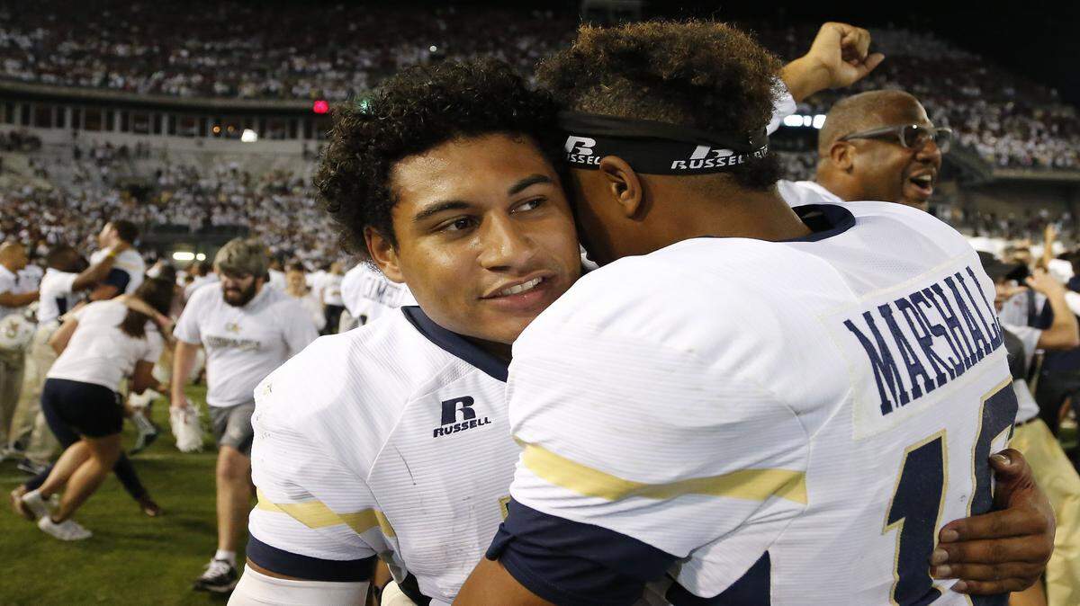 Georgia Tech quarterback Justin Thomas, left, embraces Georgia Tech running back TaQuon Marshall after the second half of an NCAA college football game against Florida State, Saturday, Oct. 24, 2015, in Atlanta. Georgia Tech won 22-16. (AP Photo/Mike Stewart)