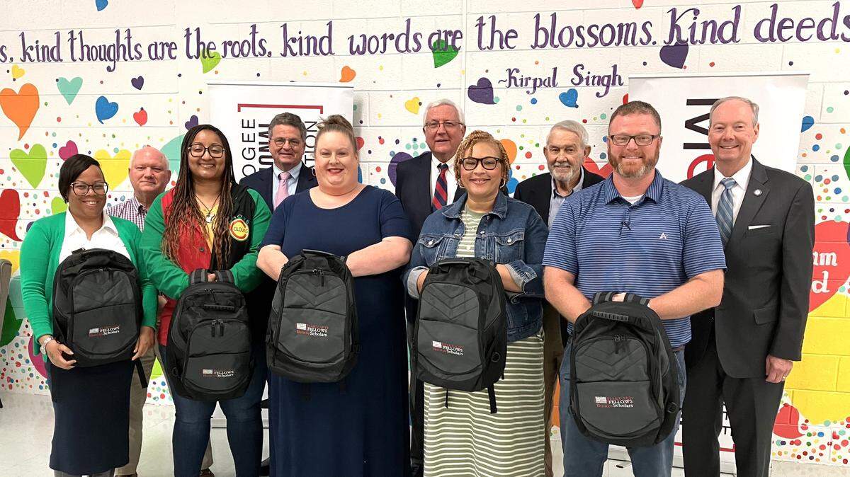 The 2024 Buntin Scholars show the backpacks they were given at the March 26 announcement in Dimon Magnet Academy. Posing with them are Muscogee County School District superintendent David Lewis (back row, far right) and retired MCSD superintendent Jim Buntin (back right, second from right), along with some members of the lunch group that donated $56,000 to establish the program in Buntin’s honor, paying for MCSD teachers from schools serving impoverished students to attend a national conference for professional development.