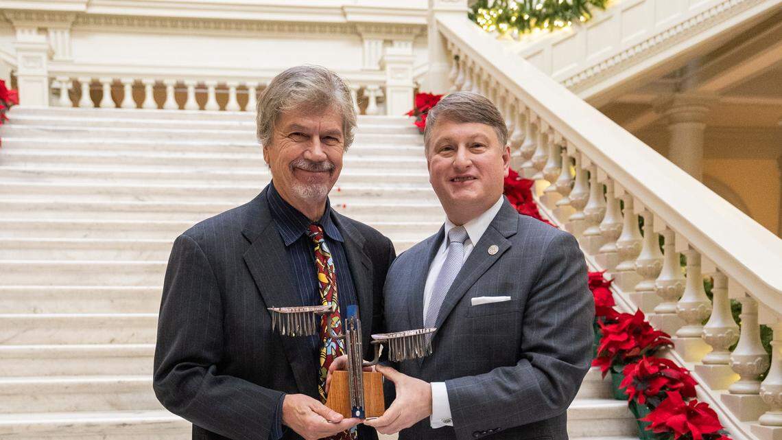 Commissioner Pat Wilson of the Georgia Department of Economic Development, right, presents Columbus artist Garry Pound with one of the 10 Governor’s Awards for the Arts and Humanities during the ceremony Dec. 5, 2024, at the Georgia Capitol in Atlanta.