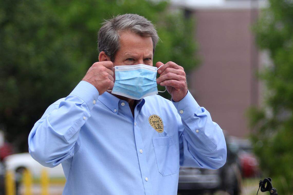 Georgia Governor Brian Kemp puts on a mask after speaking during a tour around the state to encourage mask usage at Piedmont Columbus on July 1, 2020.