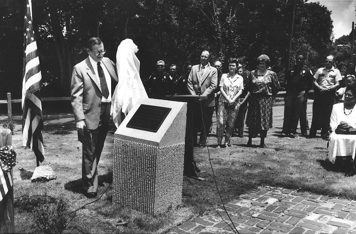 Bibb City Mayor Marvin Hethcox (left, with Drape) unveils a monument to slain Columbus Police Department officer Shirley Winston in Bibb City.
