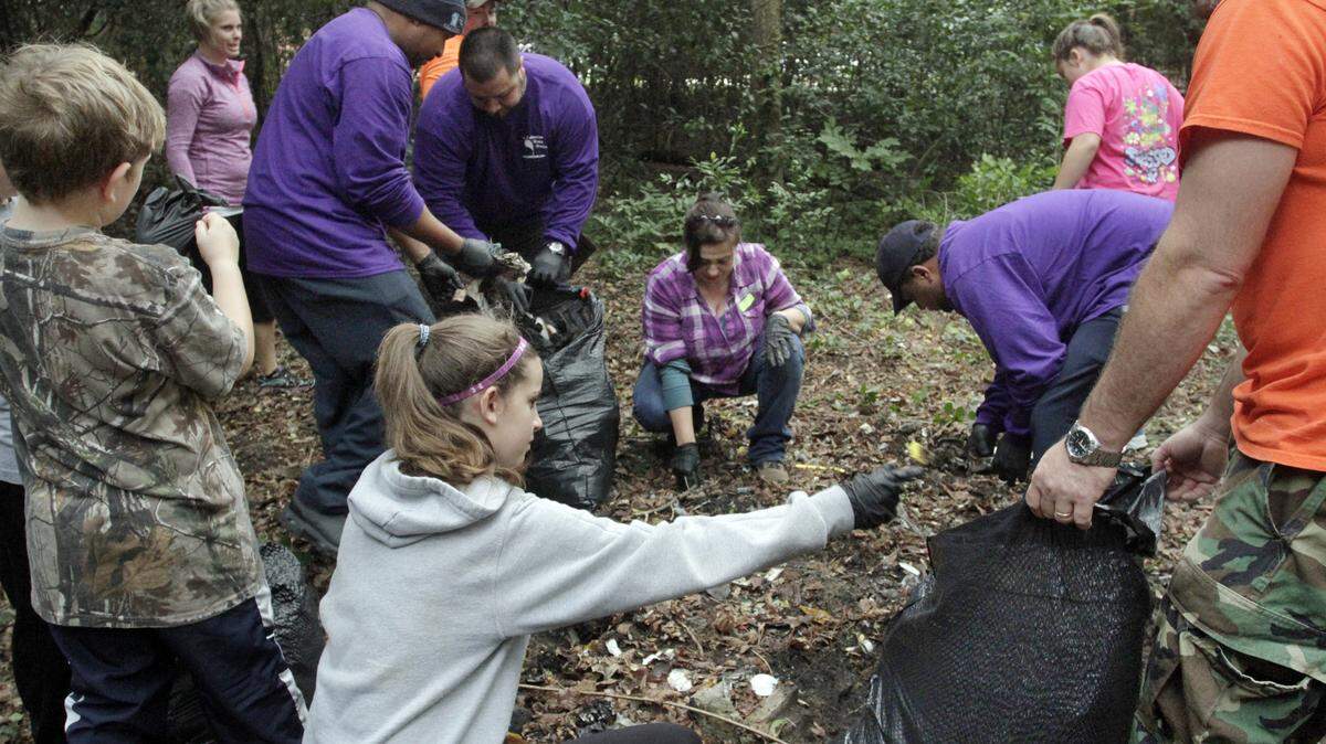 FILE -- A group of Columbus Water Works employees and their families clear debris from the woods between First Avenue and the Chattahoochee River as part of the annual Help the Hooch clean up on Oct. 3, 2015.