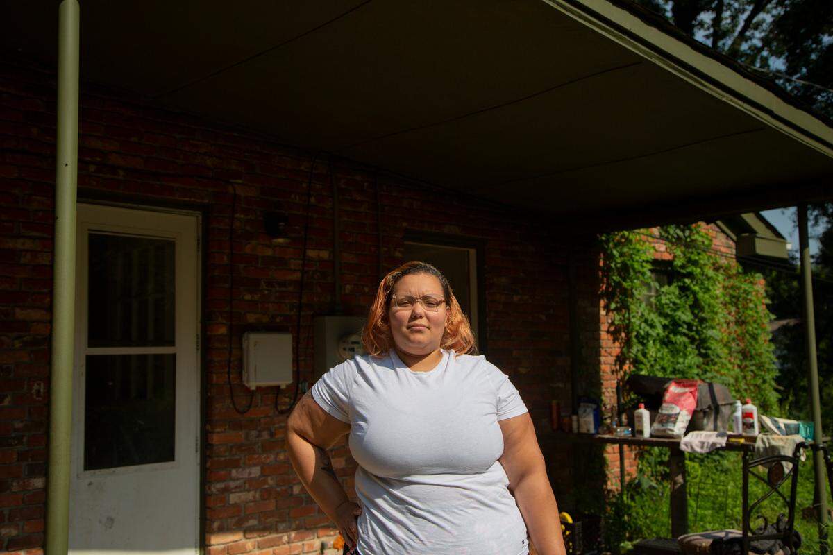 Jenell Nash stands outside of her home in Columbus, Ga. on August 9, 2021. During the pandemic, Nash transitioned jobs while supporting her four children. St. Anne Community Outreach helped her when she fell behind on rent.