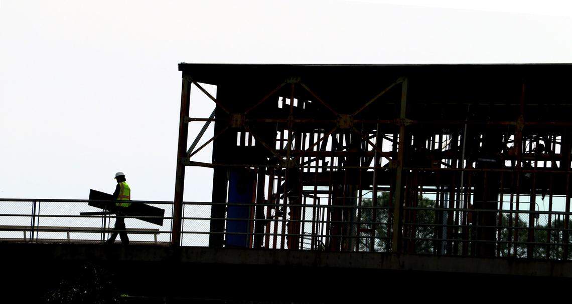 Workers carry debris to a dumpster while working on the suite level at Golden Park in Columbus, Georgia. 04/17/2024