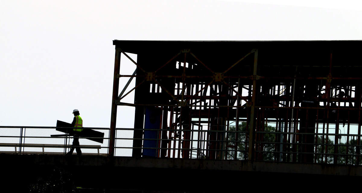 Workers carry debris to a dumpster while working on the suite level at Golden Park in Columbus, Georgia. 04/17/2024