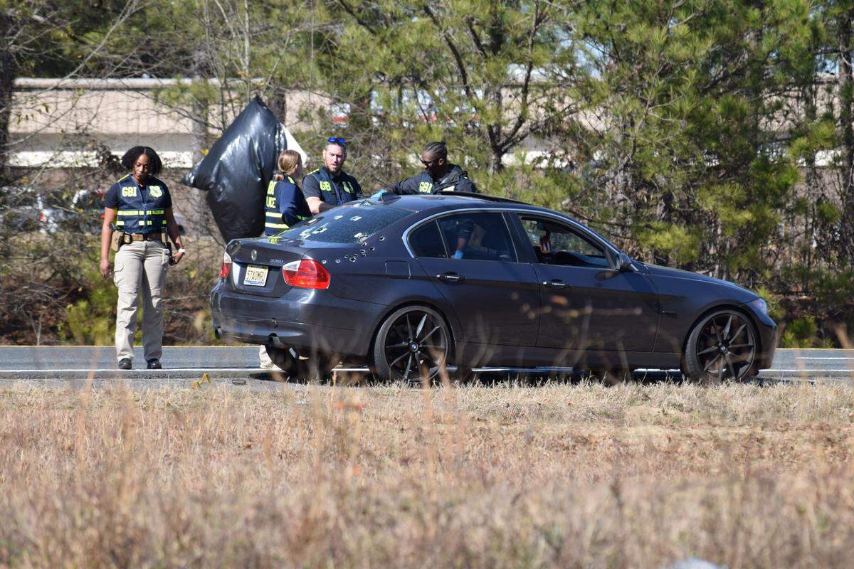 Georgia Bureau of Investigation investigators go over the vehicle that was involved in the Columbus Police Department officer-involved shooting.