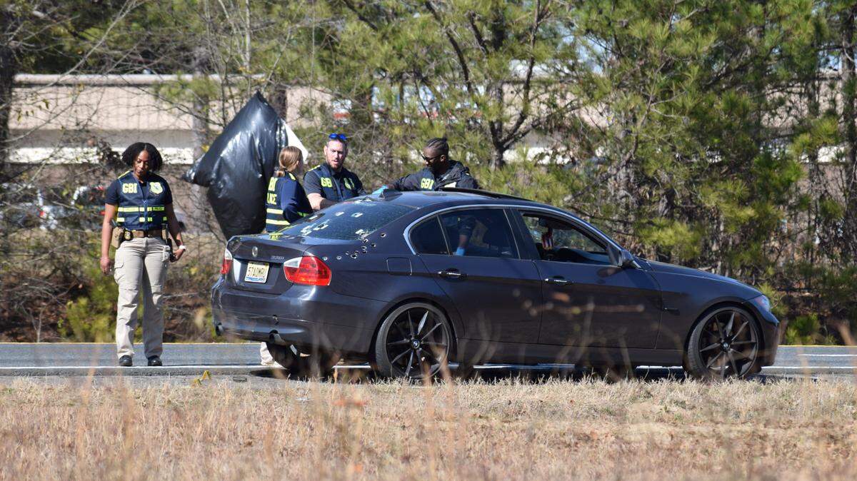 Georgia Bureau of Investigation investigators go over the vehicle that was involved in the Columbus Police Department officer-involved shooting.