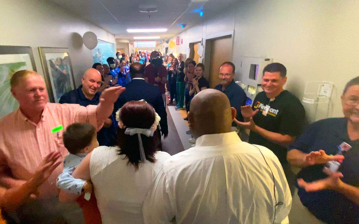 Alexander Ramirez Santos and his wife Heather walk through a hallway filled with family and well-wishers after the couple was married at Piedmont Columbus Regional’s Midtown Campus Wednesday afternoon. Pastor Marlon Scott officiated the ceremony. 07/20/2023