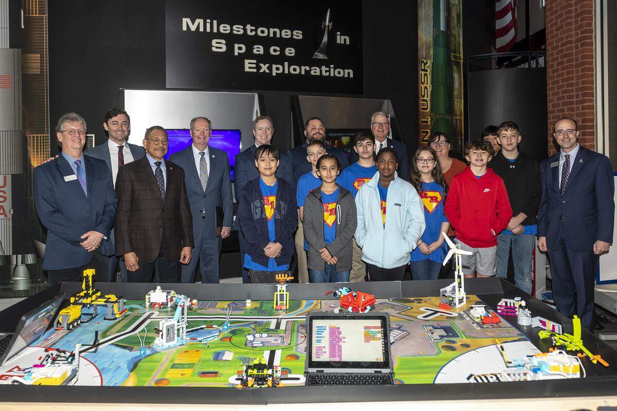 U.S. Senator Jon Ossoff, Congressman Sanford D. Bishop, Jr., Columbus State University leaders, Columbus community leaders, and students from Veterans Memorial Middle School pose for a photograph at the CSU’s Coca-Cola Space Science Center after the press conference. 01/19/2023