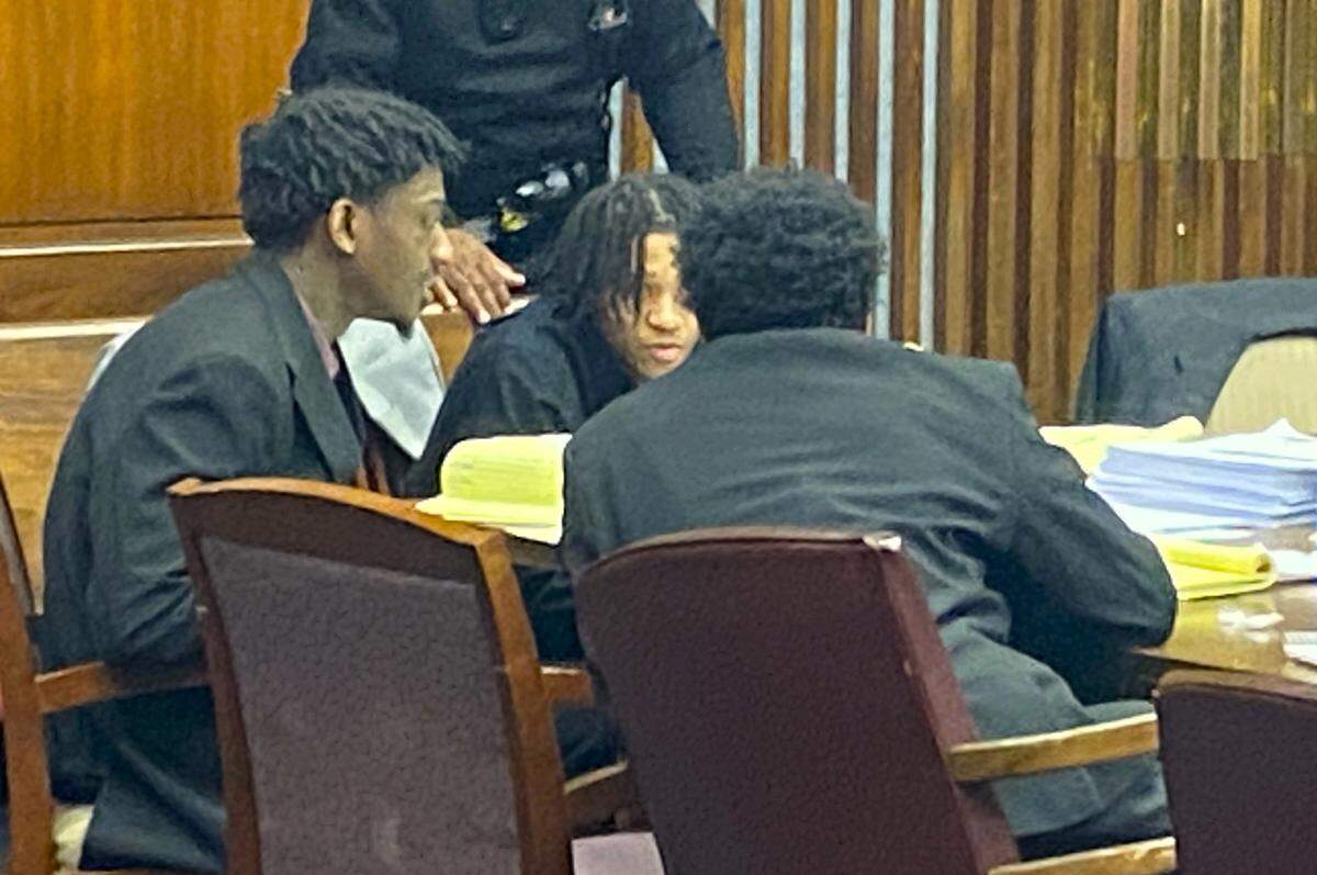 Left to right, defendants Corey Troupe and Davion Dupas talk to Jahiem Davis.