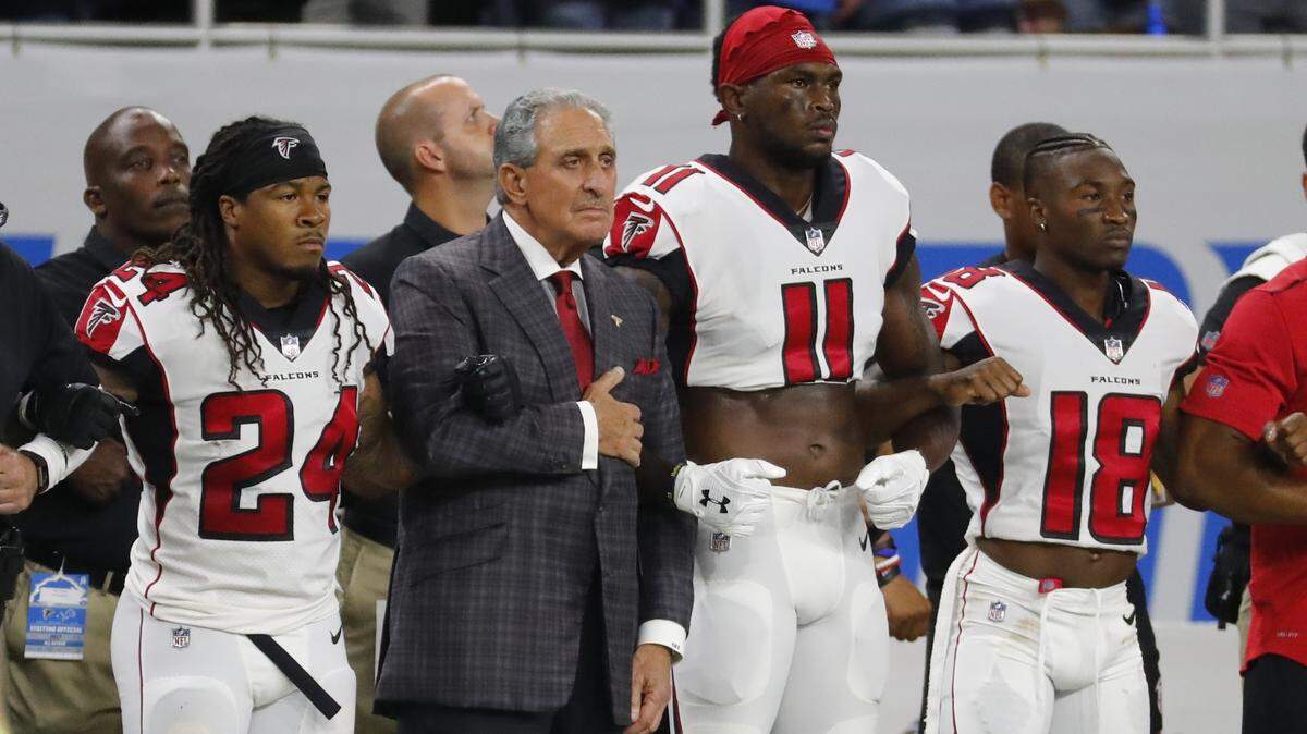 Atlanta Falcons owner Arthur Blank stands with his players during the national anthem before an NFL football game against the Detroit Lions, Sunday, Sept. 24, 2017, in Detroit