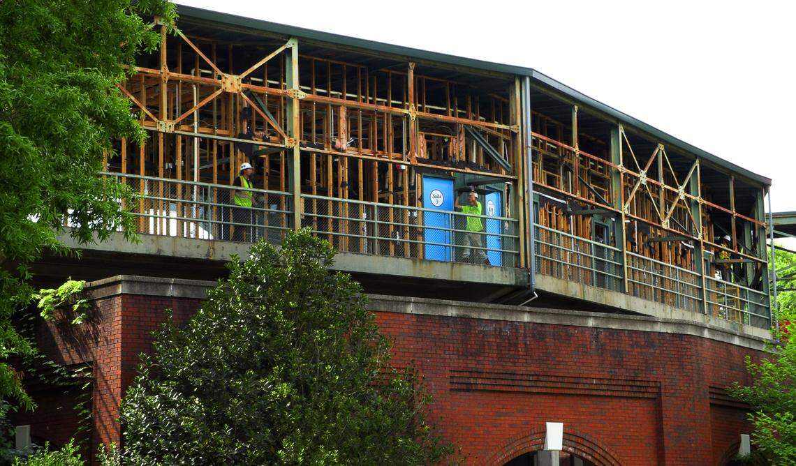 Workers carry debris to a dumpster while working on the suite level at Golden Park in Columbus, Georgia. 04/17/2024