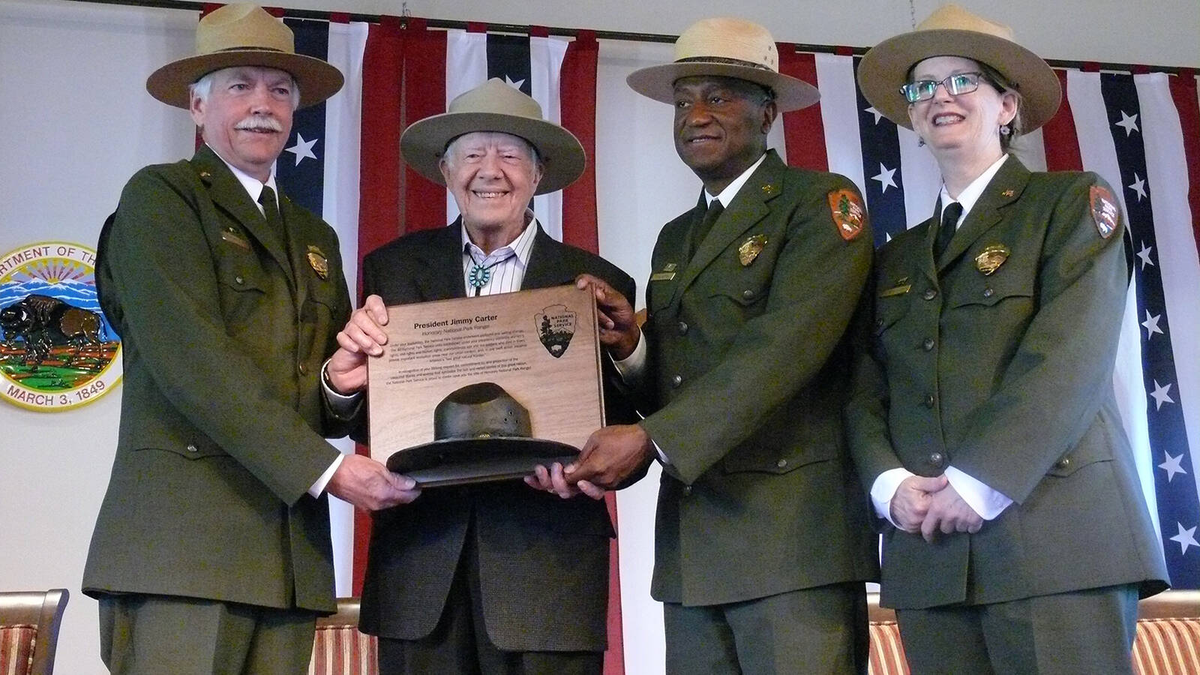 Former President Jimmy Carter receives the title of honorary national park ranger in 2016 from National Park Service Director Jonathan B. Jarvis, far left