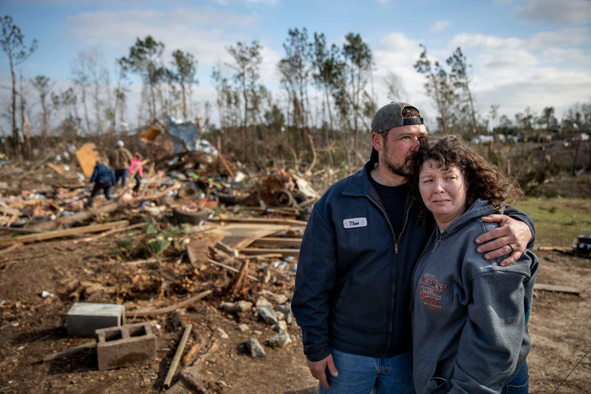 Carol Dean, right, is embraced by David Theo Dean as they sift through the debris of the home Carol shared her husband and David’s father, David Wayne Dean, who died when a tornado destroyed the house in Beauregard, Ala. “He was my wedding gift,” said Dean of her husband whom she married three years ago. “He was one in a million. He’d send me flowers to work just to let me know he loved me. He’d send me some of the biggest strawberries in the world. I’m not going to be the same.”