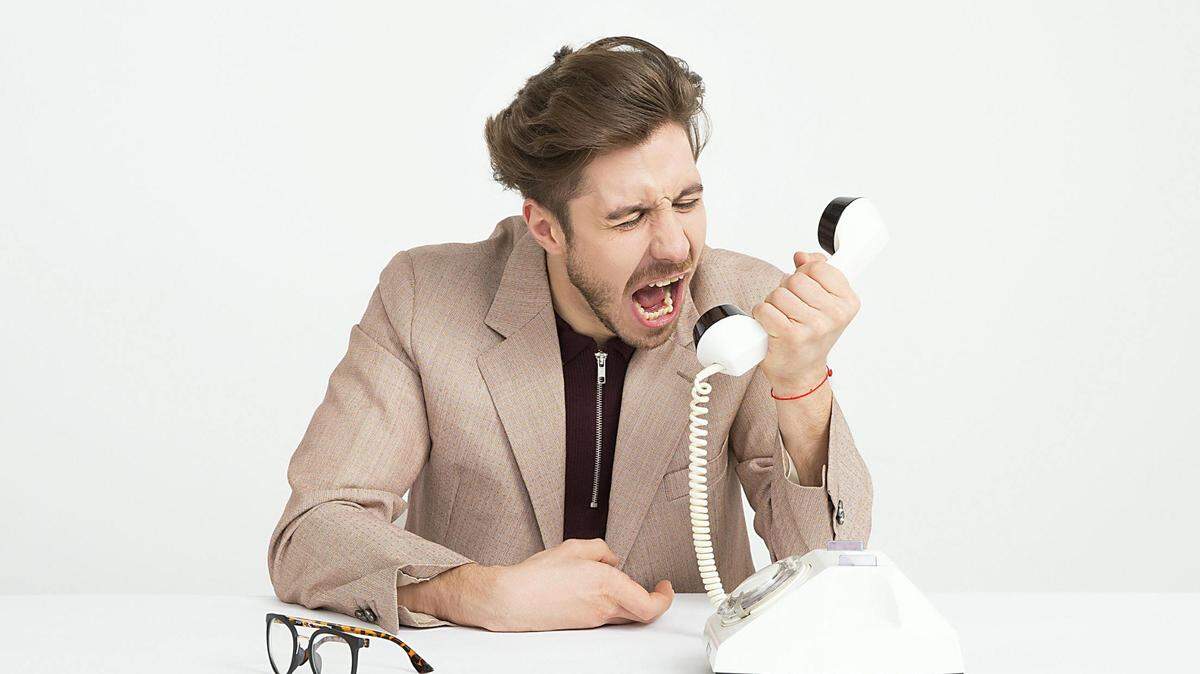 https://www.pexels.com/photo/man-wearing-brown-suit-jacket-mocking-on-white-telephone-1587014/