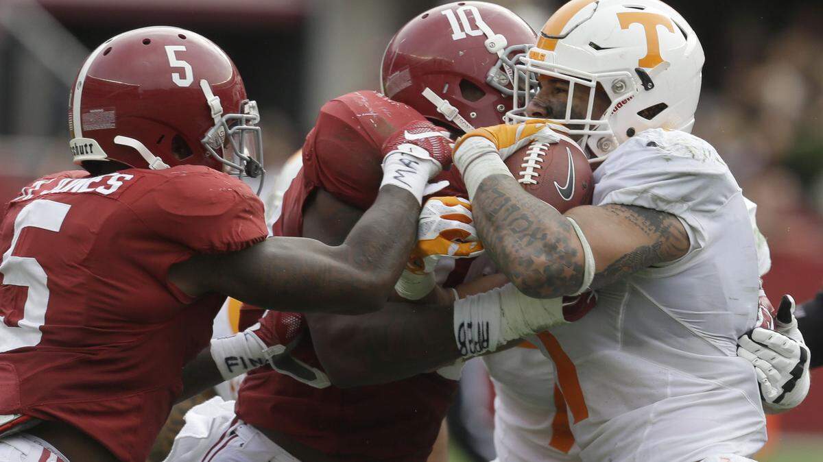 Tennessee running back Jalen Hurd (1) is stopped by Alabama linebacker Reuben Foster (10) and defensive back Cyrus Jones (5) during the second quarter of an NCAA college football game, Saturday, Oct. 23, 2015, in Tuscaloosa, Ala. (AP Photo/Butch Dill)