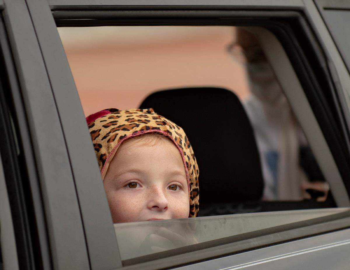 A girl peeks out of her car window at a sinister nun during the Spooktacular Trunk or Treat event on Sunday, Oct. 25, 2020 at the Civic Center in Columbus.