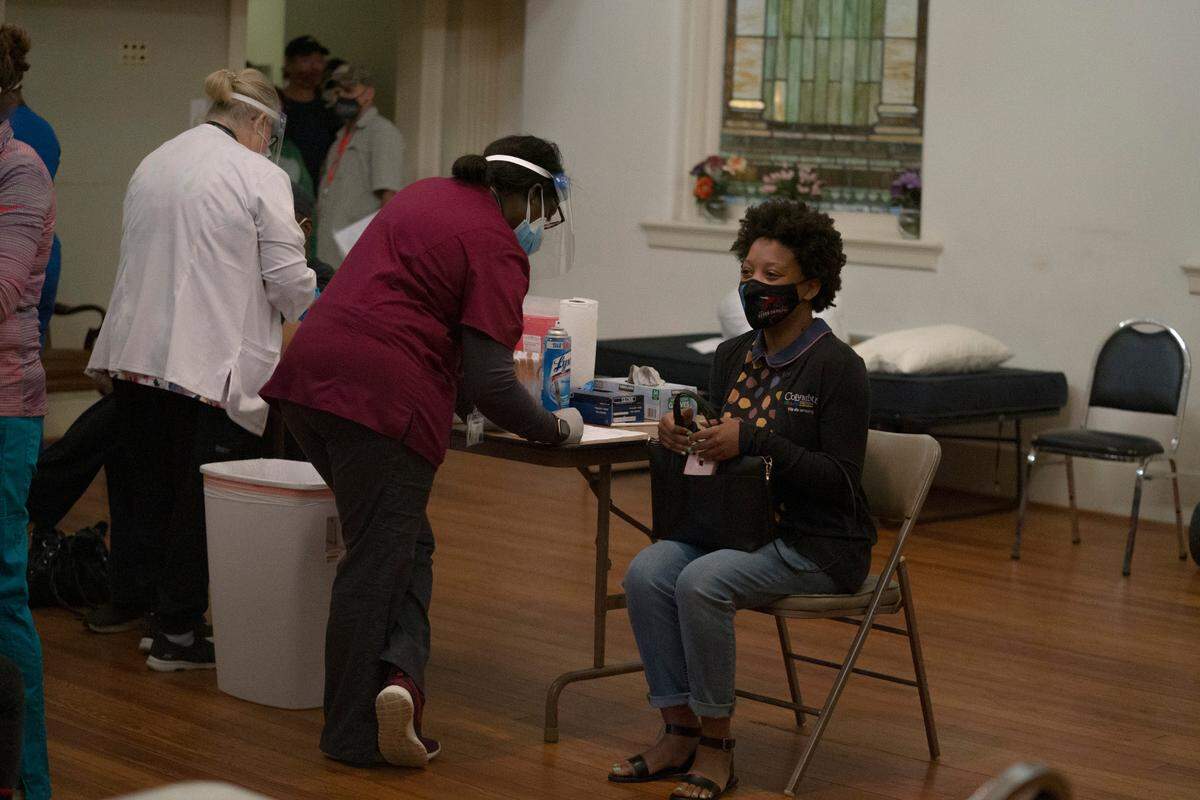 A woman waits to be vaccinated on Friday, April 9, 2021 at Safehouse Ministries in Columbus, Ga. The community center vaccinated its support staff and clients experiencing homelessness.
