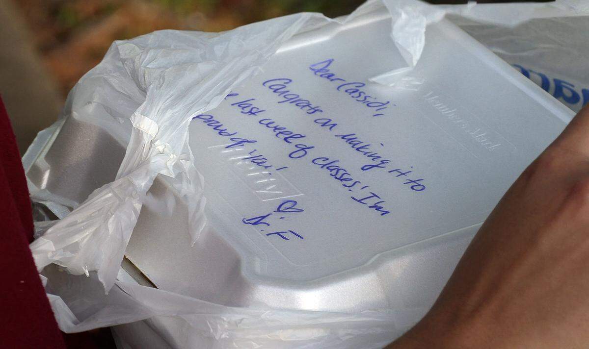 Michelle Folta, associate professor of music education at Columbus State University, writes notes to each student who picks up dinner from Folta’s front porch as part of Folta’s ‘porch picnic.”. After Columbus State University campuses closed due to the coronavirus pandemic (COVID-19), Folta created the ‘porch picnic’ as way to feed hungry students who couldn’t go home.