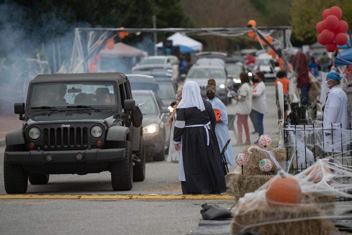 Dozens of volunteers with the city and local businesses distribute candy while socially-distancing and wearing masks during the Spooktacular Trunk or Treat event on Sunday, Oct. 25, 2020 at the Civic Center in Columbus.