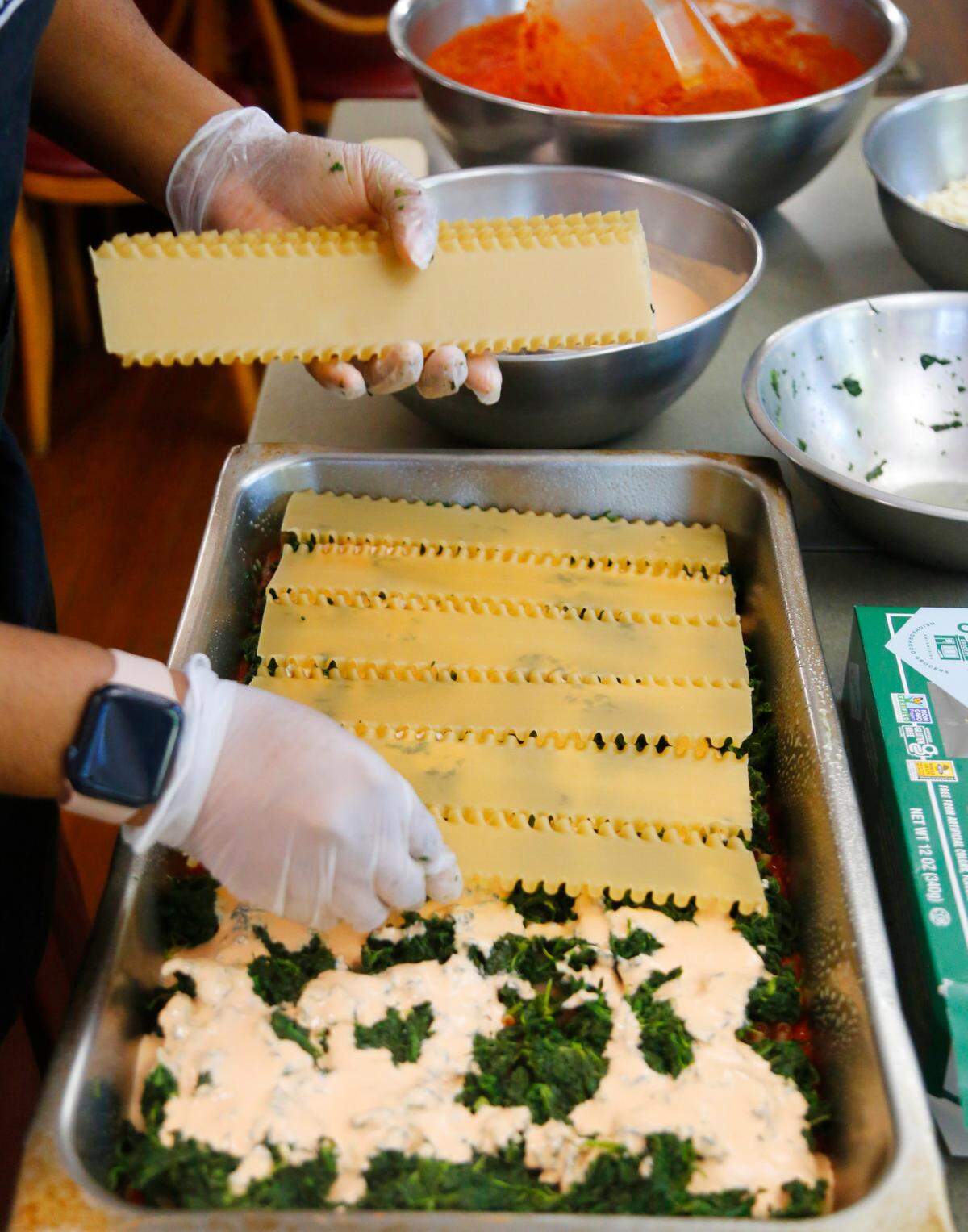 Terriann White, the kitchen supervisor at Country Life in Columbus, prepares a pan of their well-loved vegan lasagna recipe that uses brown rice lasagna. 05/05/2025
