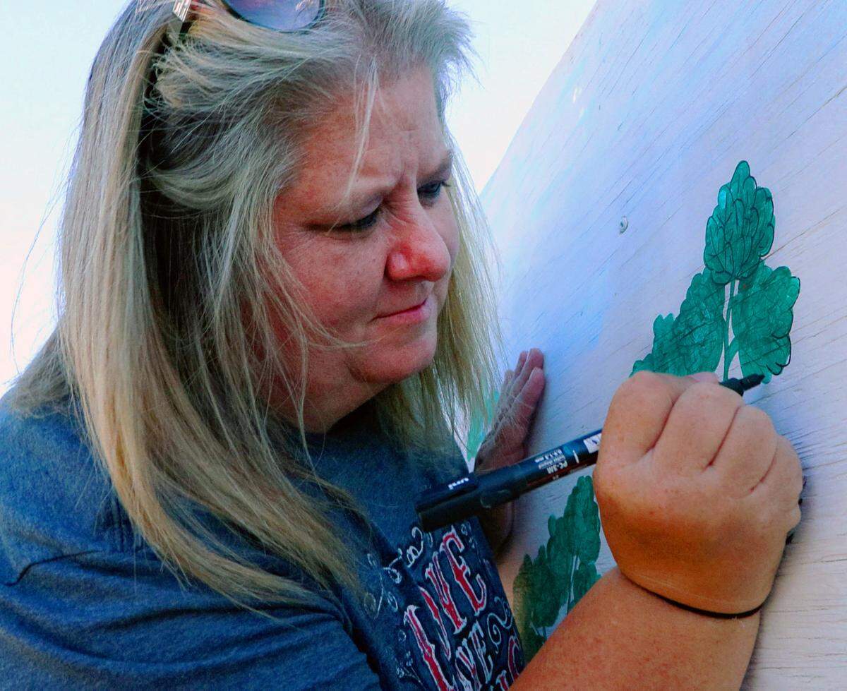 Pamela Smith paints a collard green on a mural at MercyMed Farm in Columbus. Smith will be a competitor at the 3rd Annual Collards Cook-Off at MercyMed Farm, scheduled for Oct. 24, 2025, from 4-7 p.m. The event includes live music, food, vendors, fresh farm veggies and pumpkin decorating for kids. Admission is free, but the Collards Cook-Off tasting requires a $5 donation per person.