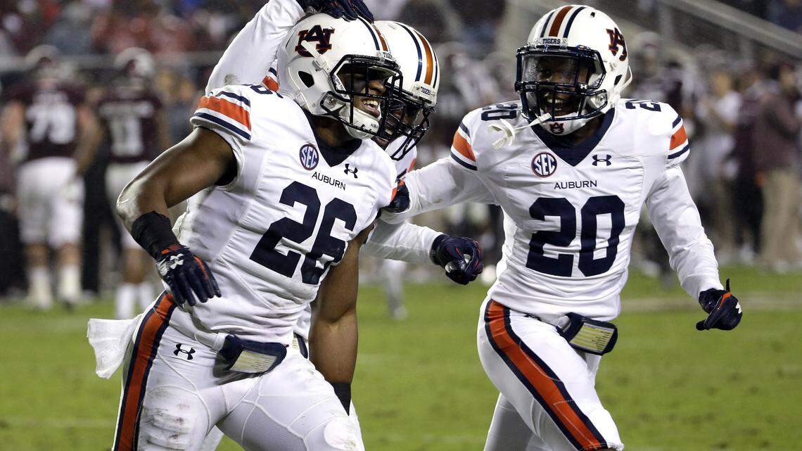 Auburn linebacker Justin Garrett (26) is congratulated by teammates Tre' Williams, center, and Jeremiah Dinson (20) after intercepting a pass against Texas A&M during the second quarter of an NCAA college football game Saturday, Nov. 7, 2015, in College Station, Texas. (AP Photo/David J. Phillip)