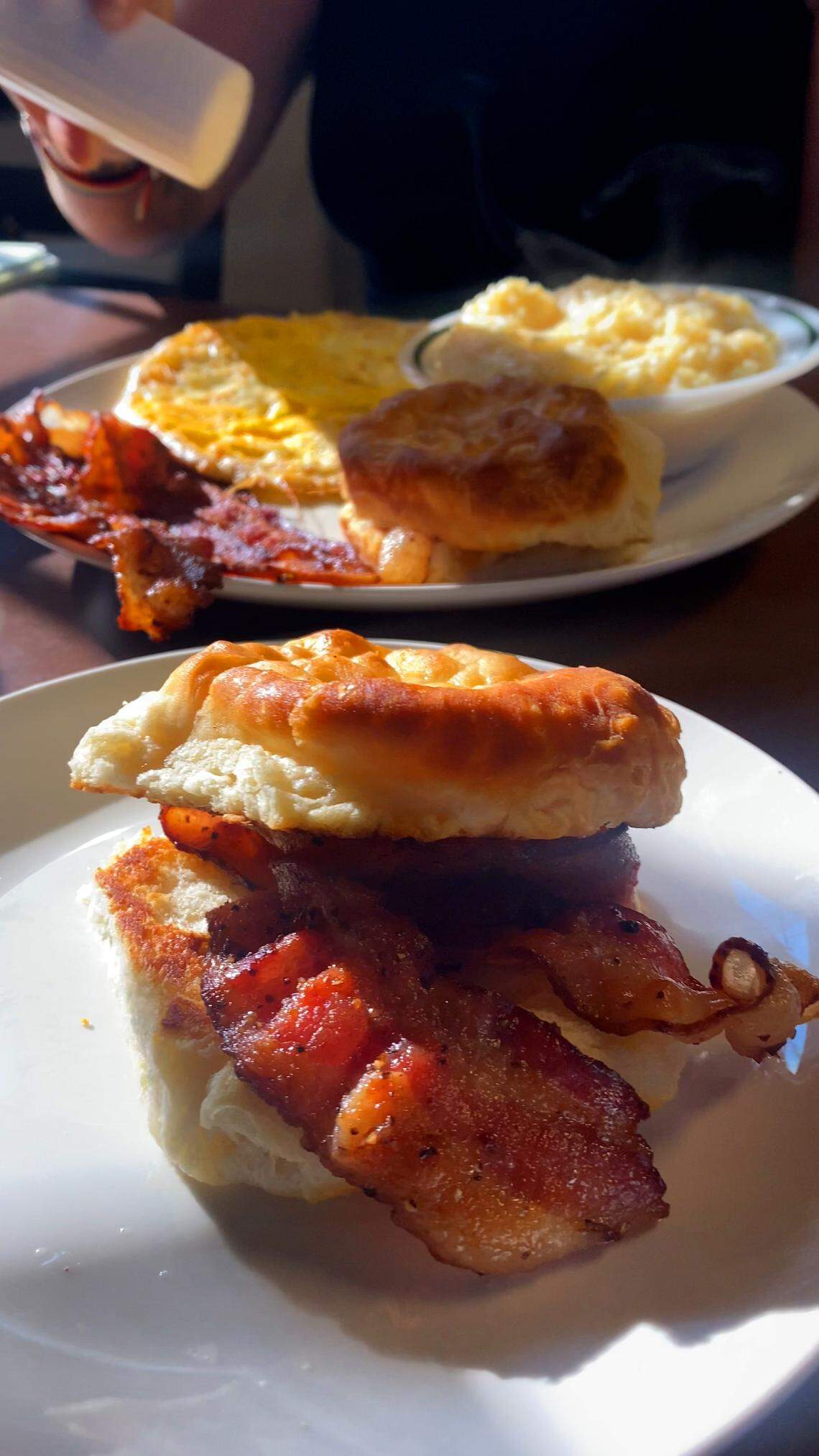 For this installment of “Columbus on a Budget” visual journalist Mike Haskey opted for a biscuit with bacon, front, and reporter Sundi Rose ordered the Basic Training Eggs to Order, with bacon, for breakfast at Darby’s Patrol Base in Columbus, Georgia. 08/15/2025