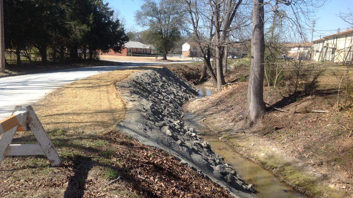 Mike Owen/mowen@ledger-enquirer.comThe city used large rocks and concrete to shore up this eroding creek bank on Booth Street.