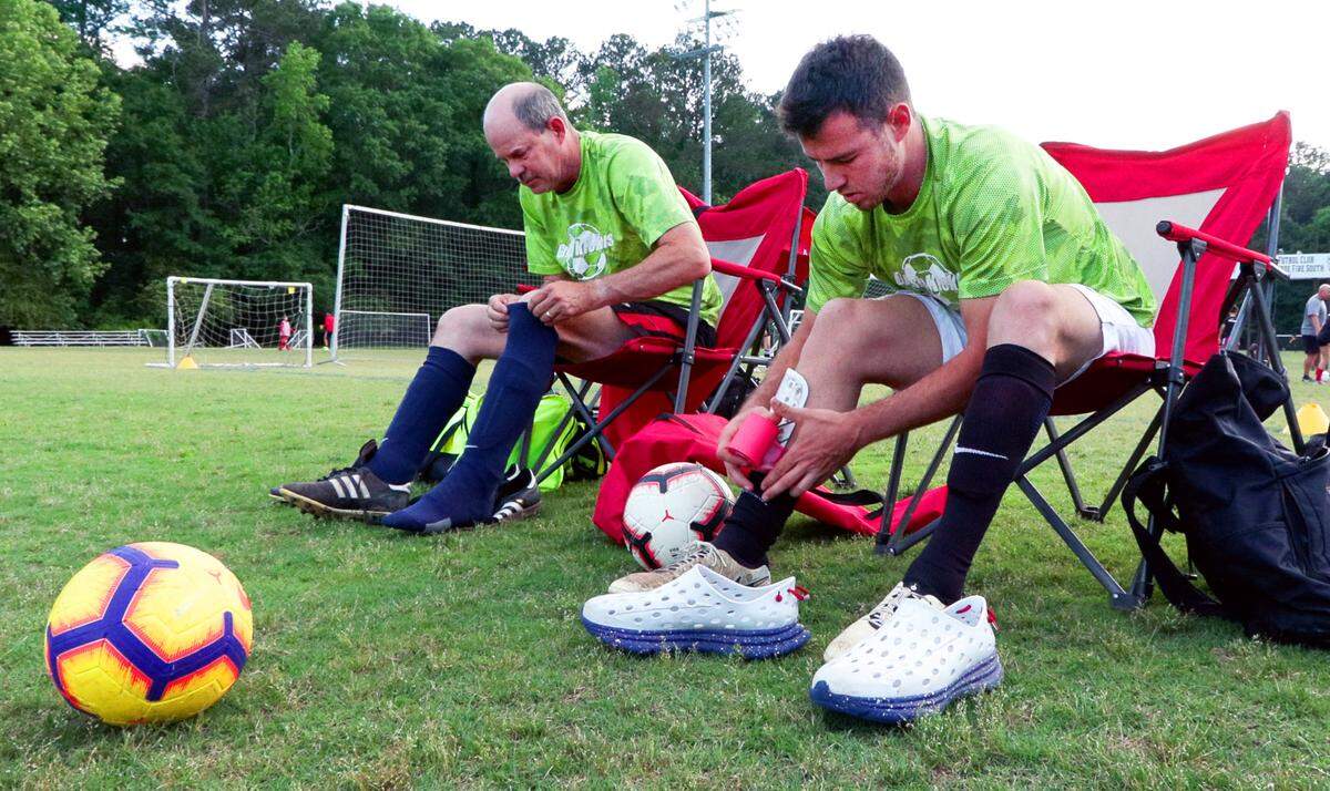 Jacob Crumbley, right, and his father Mike Crumbley, prepare to play in an adult league soccer game recently at Woodruff Farm Soccer Complex in Columbus, Georgia.