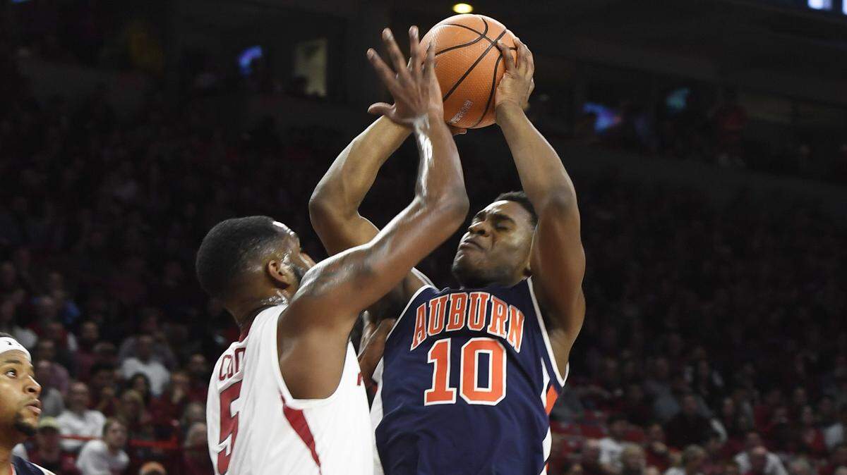 Auburn guard Davion Mitchell takes a shot over Arkansas defender Arlando Cook during the first half of an NCAA college basketball game Tuesday, Feb. 27, 2018, in Fayetteville, Ark.