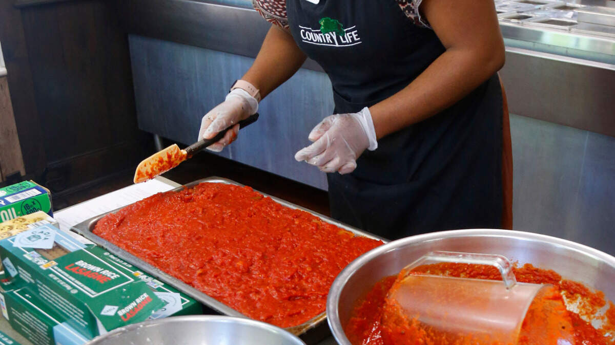 Terriann White, the kitchen supervisor at Country Life, prepares a pan of their well-loved vegan lasagna recipe that uses brown rice lasagna. 05/05/2025