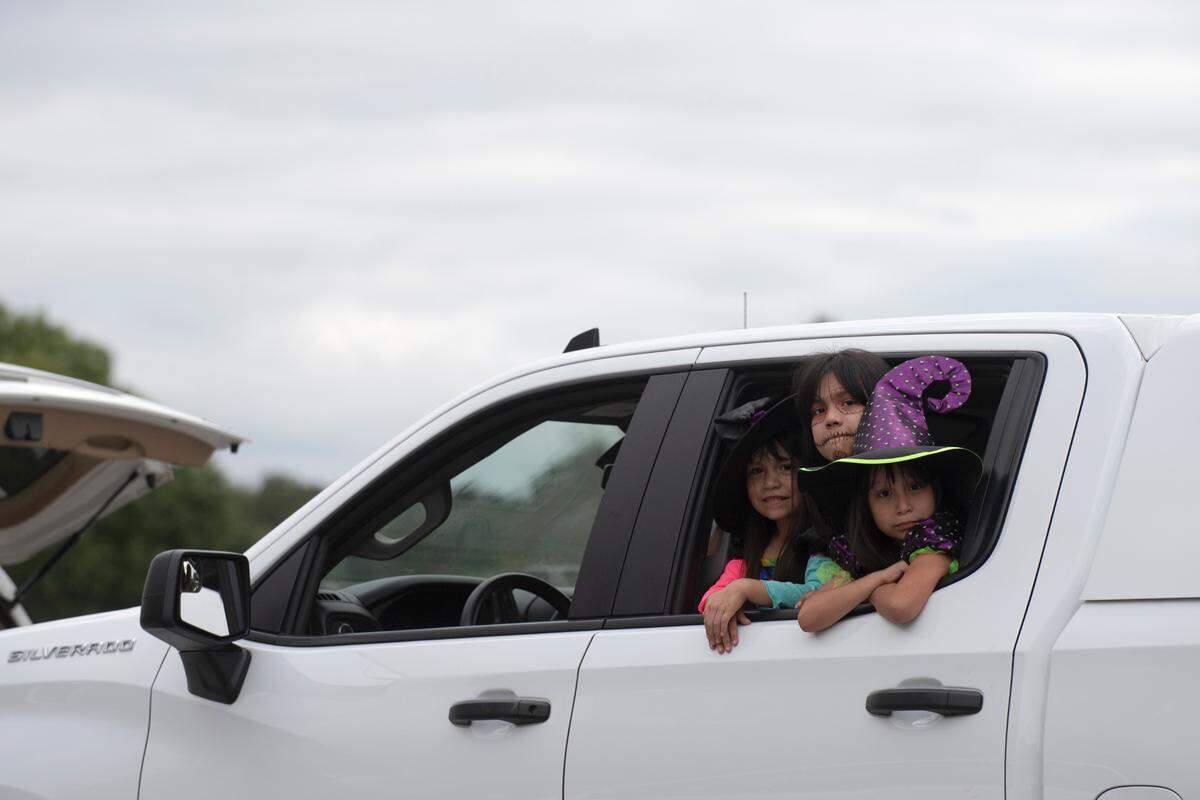 A trio of witches wait in line with a popped trunk to collect candy at the Spooktacular Trunk or Treat event on Sunday, Oct. 25, 2020 at the Civic Center in Columbus.