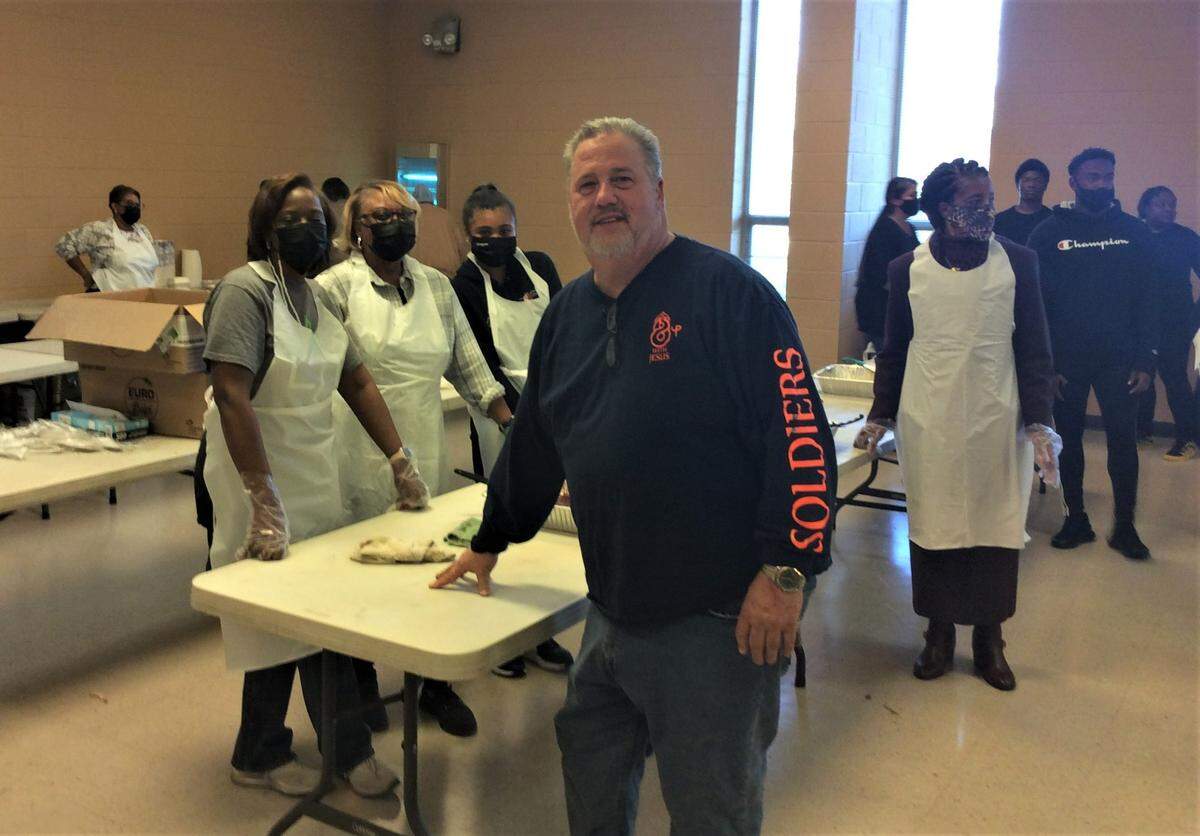 Ernie Perritt, who runs a men’s addiction recovery program and coordinates food services at Columbus’ Valley Rescue Mission, stands with volunteers assembling Thanksgiving meals.