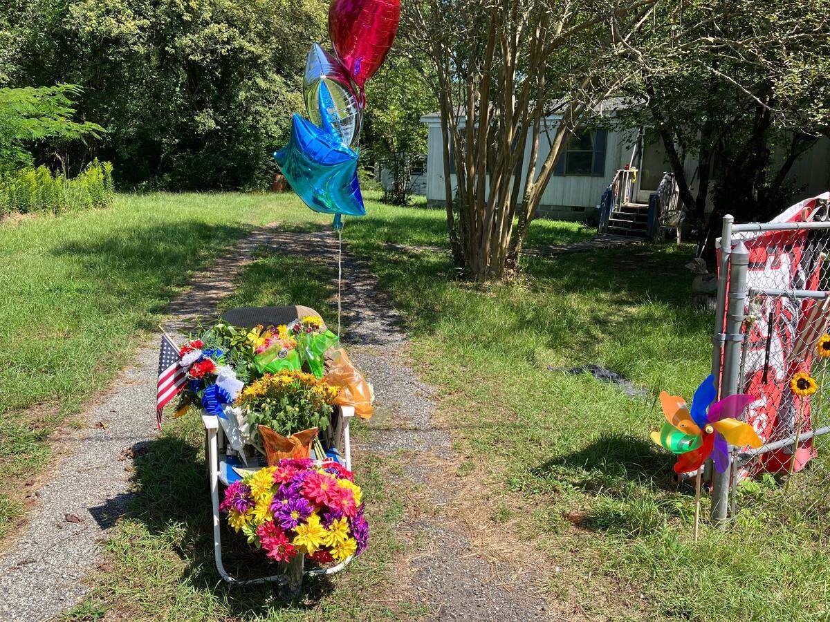 This was the scene Sept. 19 outside the home of Christopher Alan Thomas on Fortson Road in Harris County, where mourners left tributes to the man who sat in that folding chair to smile and wave to passersby each day. Thomas died Sept. 15. He was 64.