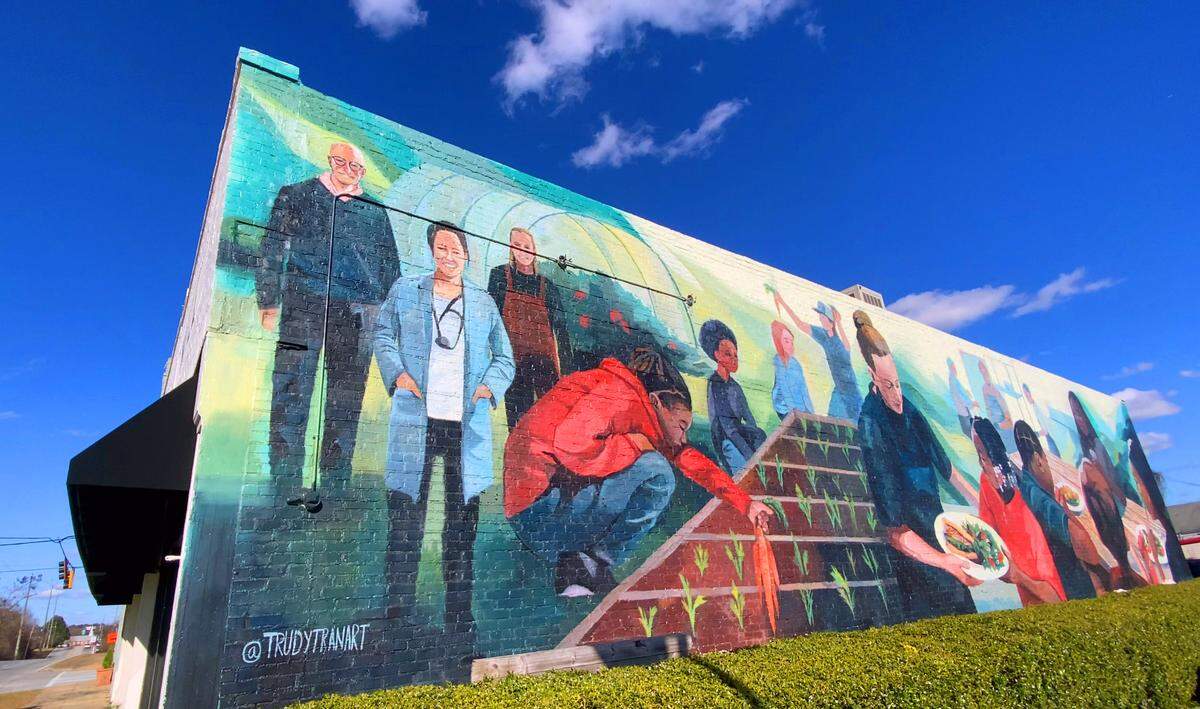 This is a large mural painted on the side of The Food Mill in Columbus, Georgia. Brittney Espersen, the general manager/chef at The Food Mill in Columbus, Georgia, is among those depicted in the mural.