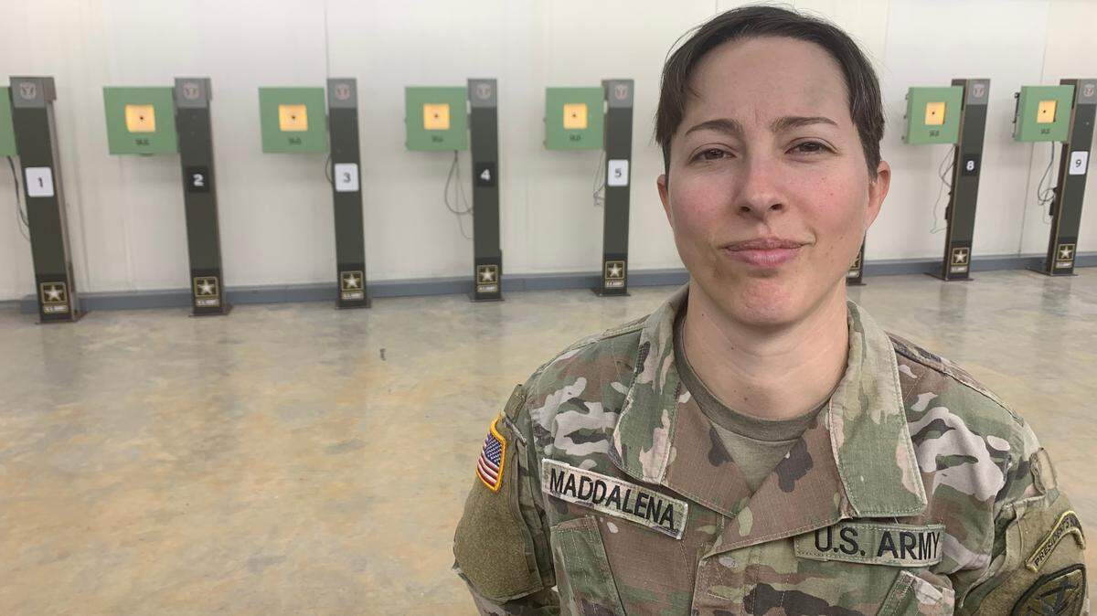 Sgt. Sagen Maddalena stands in front of a row of 10 meter air rifle targets located at a training facility at Fort Moore. Maddalena recently qualified for her second Olympic Games in the 10 meter air rifle event.