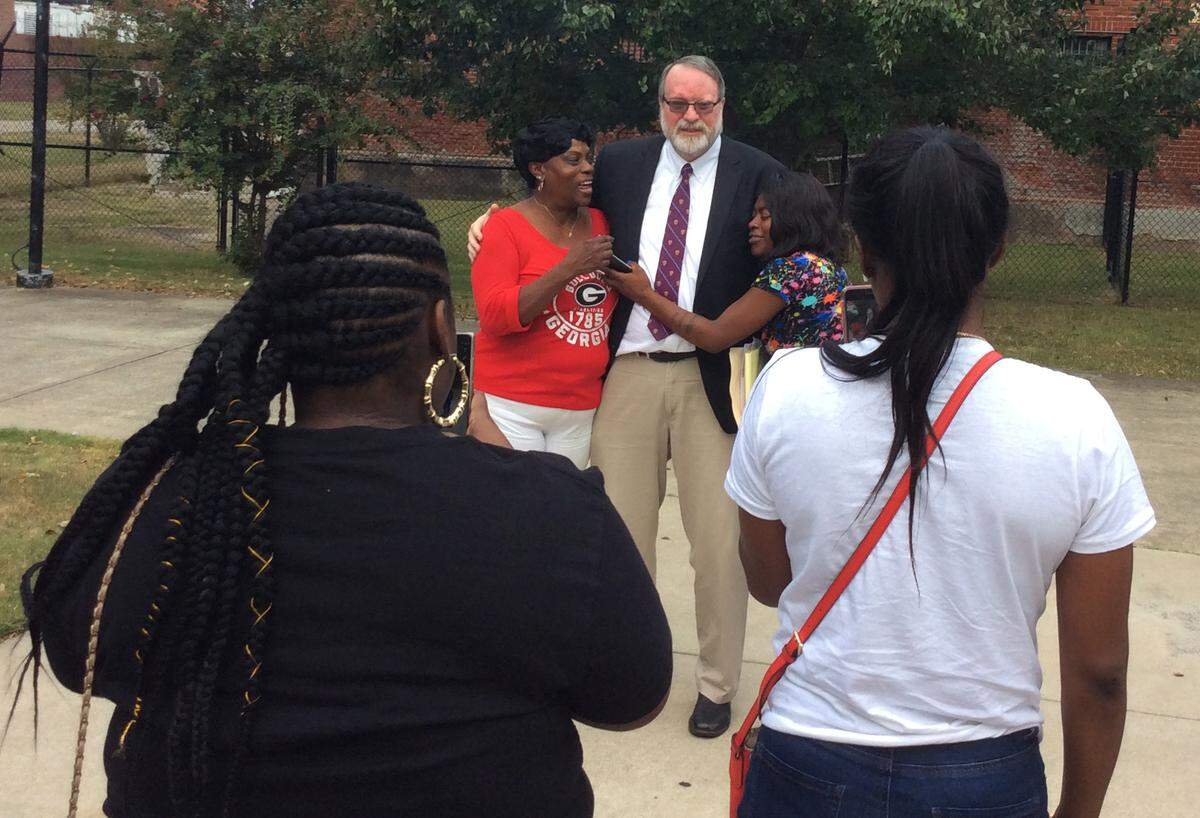 Cheryl Cartwright, left, mother of Derrick Cartwright, hugs defense attorney Mark Shelnutt,center, after a hearing in her son’s case Friday morning, Sept. 27, 2019.