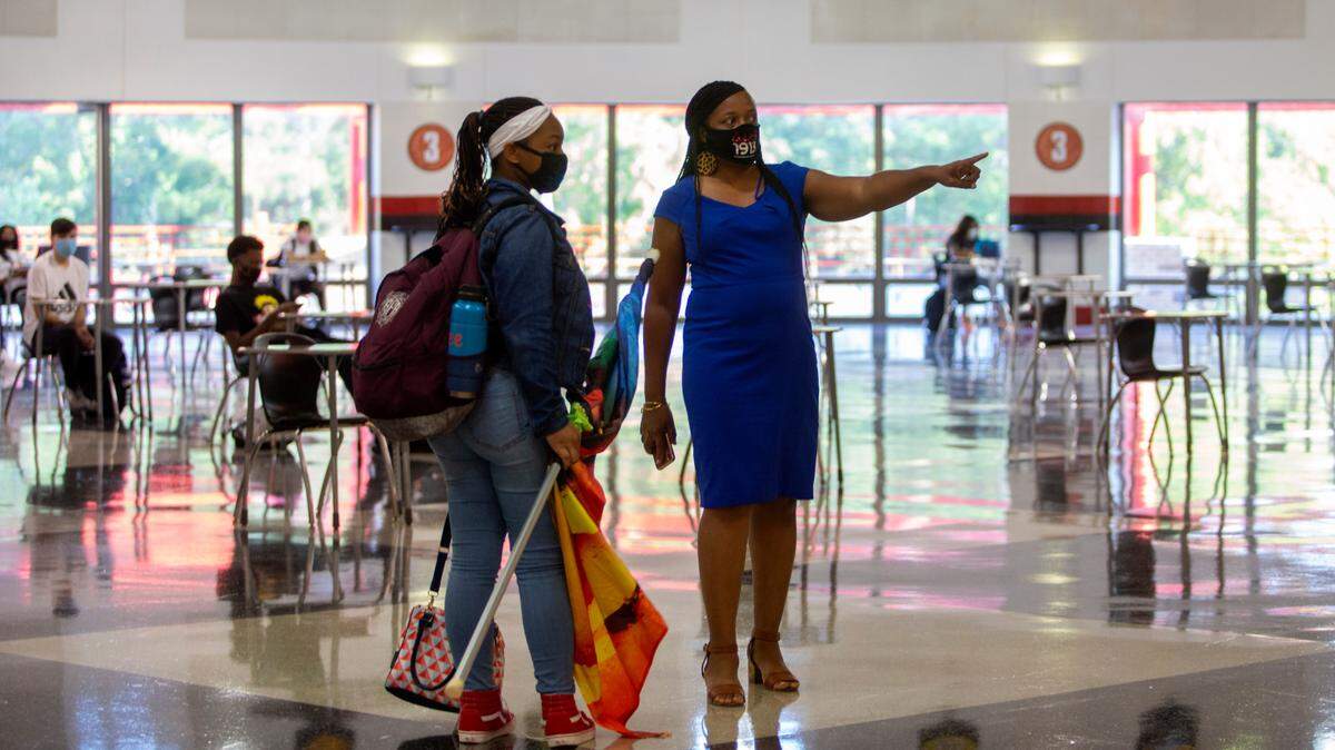 A teacher helps a new student find their way through Central High School on Tuesday, August 18, 2020 in Phenix City, Ala.
