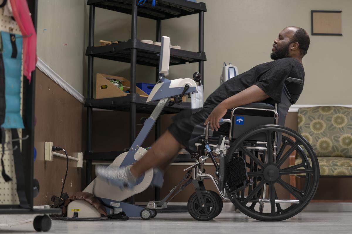 Eric Lofton spins away on an exercise bike during physical therapy, on May 26, 2021, at River Towne Center nursing facility in Columbus, Ga.
