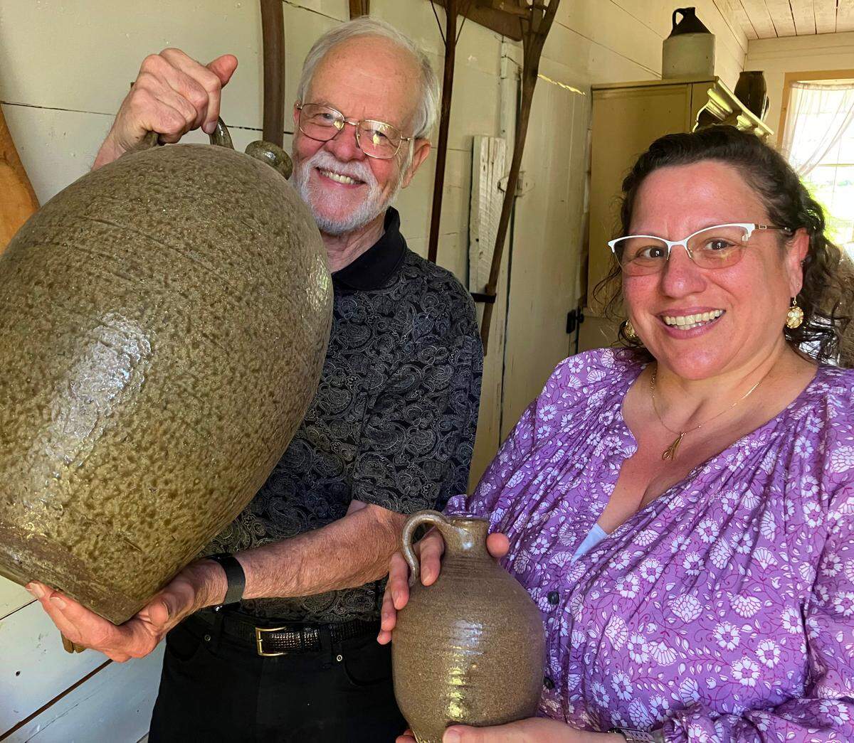 Historic Westville Village board president Thornton Jordan, left, and new Historic Westville Village executive director April Kirk, show some of the pottery at the living history museum in Columbus. 05/16/2025.