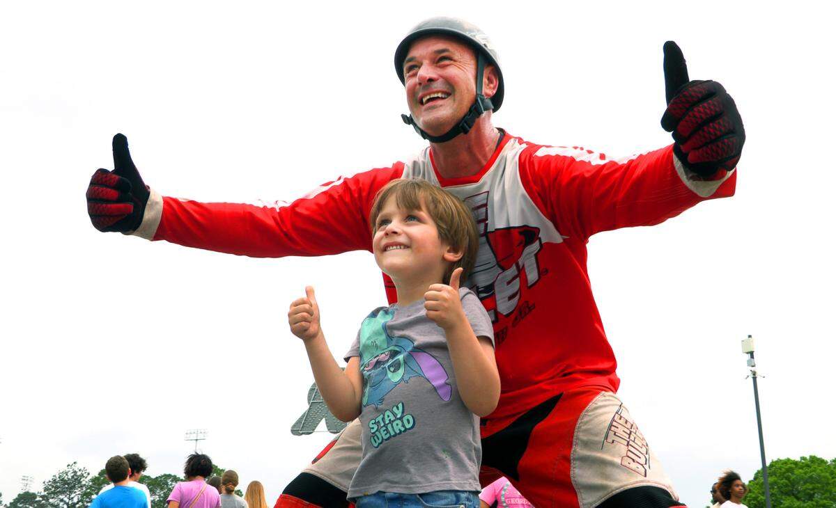 David Smith Jr., a second generation human cannonball known as “The Bullet,” poses for a photograph with a young fanTuesday night at the Spring Fling carnival at the Columbus Civic Center in Columbus. 04/02/2024