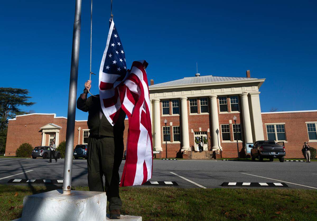 The U.S. flag is raised to half-staff Monday morning at the Plains High School Museum and Visitor Center in Plains, Georgia. 12/30/2024