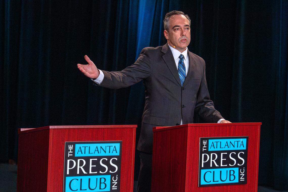 Peter Hubbard gestures toward an empty podium during the Public Service Commissioner District 3 debate on Oct. 8, 2025, at the Atlanta Press Club event.