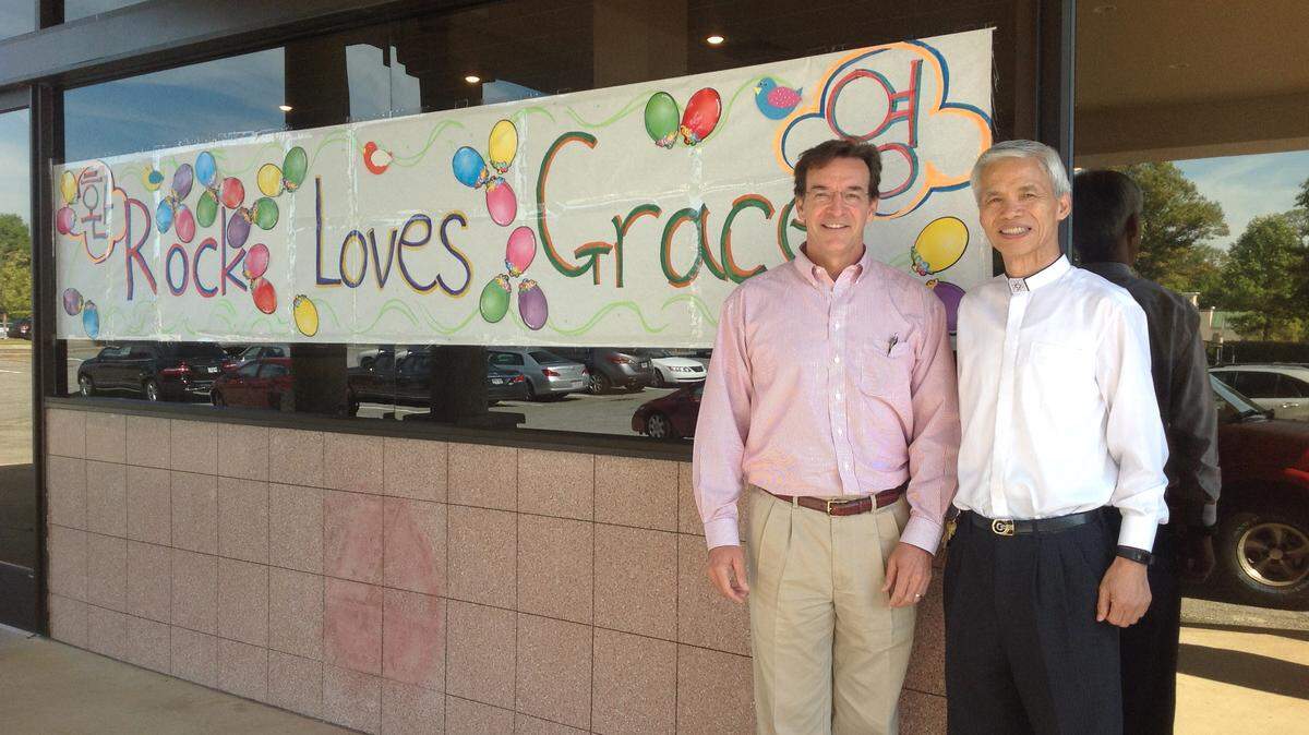Alva James-Johnson/ajjohnson@ledger-enquirer.com 
 The Rev. Chuck Hasty, pastor of Grace Presbyterian Church, and the Rev. Sam Park, pastor of Rock Presbyterian Church, stand in front of a banner created by members of the Rock to welcome Grace members to the building.
