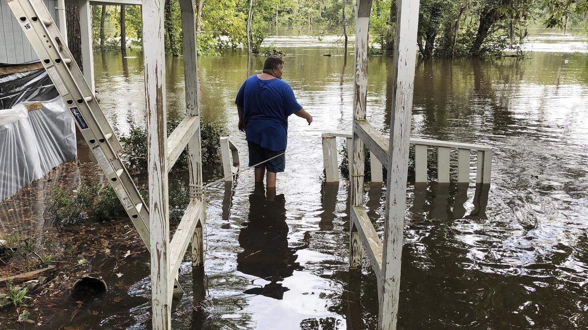 Shawn Lowrimore, Pastor Willie Lowrimore of The Fellowship With Jesus Ministries’, son, wades into water near the church in Yauhannah, S.C., on Sept. 24. The church is on the bank of the Waccamaw River, where thousands of evacuations were forced in the aftermath of Hurricane Florence.