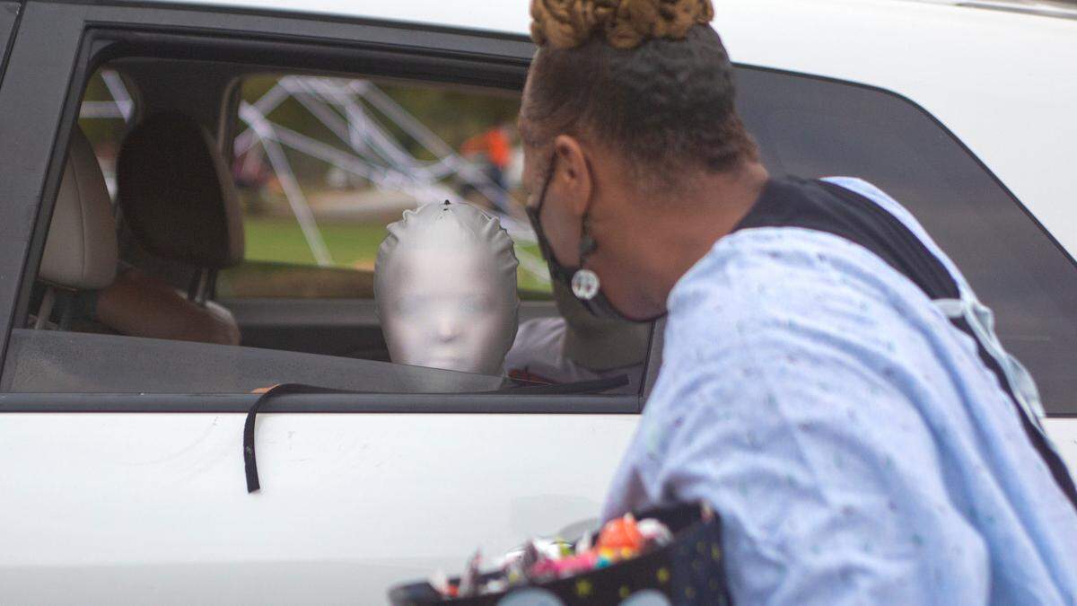 Kristell Johnson, with the Parks and Recreation Department, is surprised by a faceless costume during the Spooktacular Trunk or Treat event on Sunday, Oct. 25, 2020 at the Civic Center in Columbus.