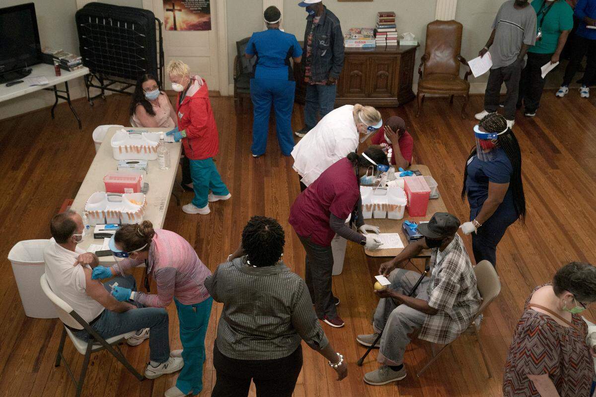 Healthcare workers from the Columbus Department of Public Health vaccinate on Thursday, April 8, 2021 at Safehouse Ministries in Columbus, Ga. The community center vaccinated its support staff and clients experiencing homelessness.