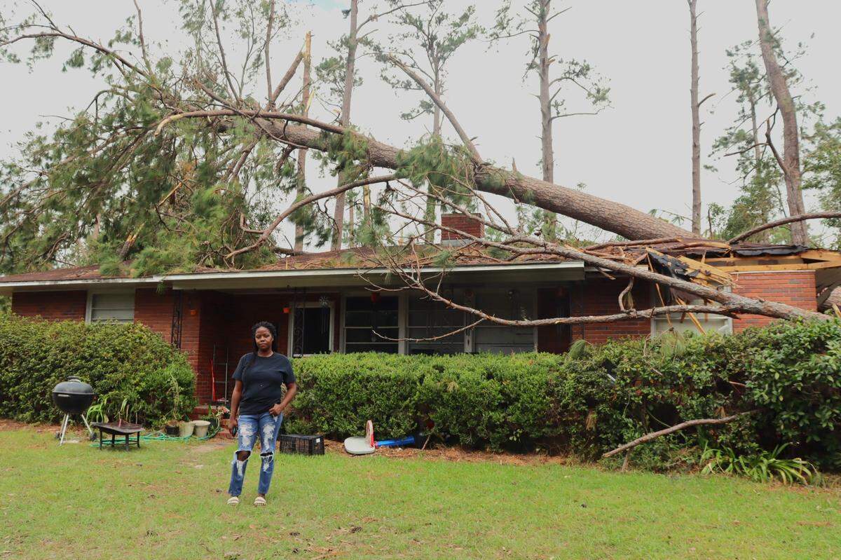 Alice Legier, 43, stands in front of her home on Park Avenue in Valdosta, Georgia a week after Hurricane Helene brought down several trees in front of and on top her home and car.